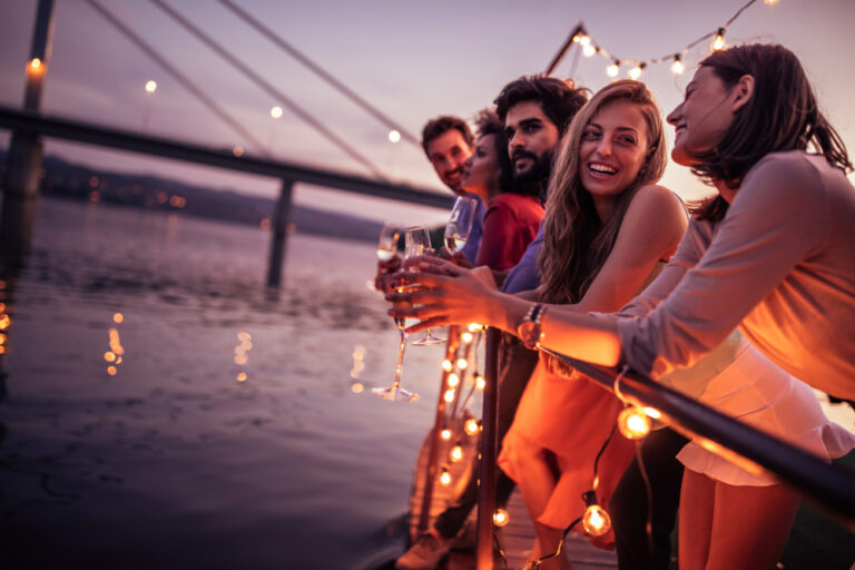Group,Of,Friends,Enjoying,Sunset,At,The,Party,By,The