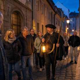 Nachtwächter mit Laterne führt eine Reisegruppe durch Würzburgs Altstadt