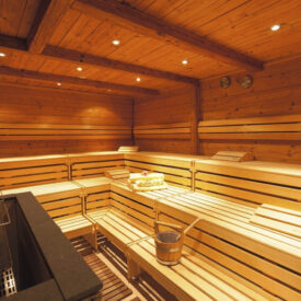 Holzsauna mit mehreren Sitzbänken.