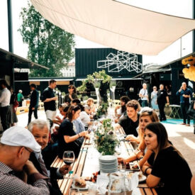 Gäste an langen Tischen in einem Biergarten in Prag