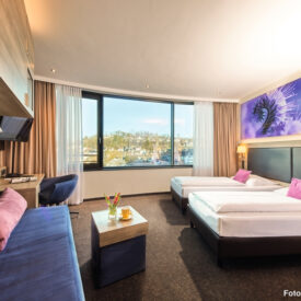 Hotelzimmer mit zwei Betten und Sitzbereich.