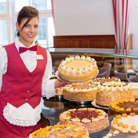 Frau steht an einem großen Kuchenbuffet in Lübeck