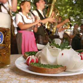 Bedienung serviert Bier und bayerische Speisen in einem Münchner Biergarten