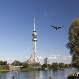Olympiaturm und Olympiasee unter blauem Himmel in München