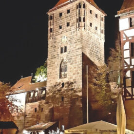 Historischer Turm und Fachwerkhäuser in Nürnberg bei Nacht