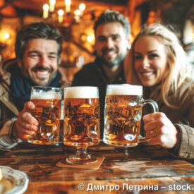 Freunde stoßen in einer Nürnberger Gaststube mit Bier an