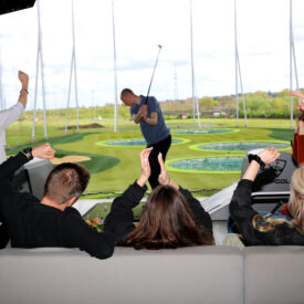 Gruppe jubelt während des Gameplays in einer TOPGOLF-Bay in Oberhausen