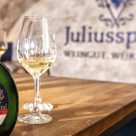 Weinflasche und Weinglas bei einer Weinprobe im Juliusspital