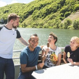 Vier Reisende bei einer geselligen Schifffahrt auf dem Rhein