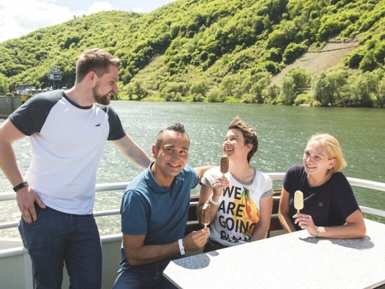 Vier Reisende bei einer geselligen Schifffahrt auf dem Rhein