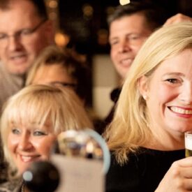 Gäste trinken gemeinsam Bier in einer Brasserie in Egmond aan Zee
