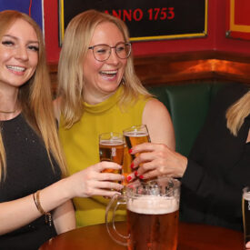 Frauengruppe sitzt mit Getränken in einem Pub in Egmond aan Zee