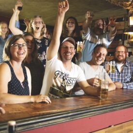Gäste feiern gemeinsam an der Bar im Wangerland Resort