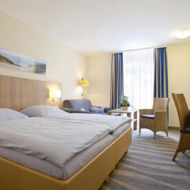 Helles Doppelzimmer mit Sitzbereich im Inselhotel Bruns