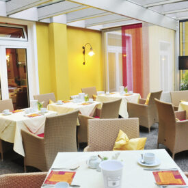Heller Frühstücksraum mit gedeckten Tischen im Inselhotel Bruns