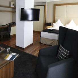 Hotelzimmer mit Bett und schwarzer Sitzecke im Inselhotel König auf Norderney