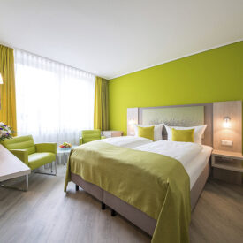 Doppelzimmer mit grünen Akzenten im Inselhotel Vier Jahreszeiten auf Norderney