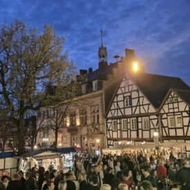 Belebter Marktplatz mit Fachwerkhäusern in Linz am Rhein am Abend