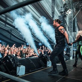 Sänger auf der Festivalbühne vor feierndem Publikum