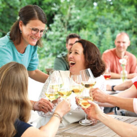 Freunde stoßen bei einem gemeinsamen Essen während ihrer Ostsee-Auszeit an