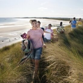 Gruppe spaziert durch die Dünen zum Strand von Norderney