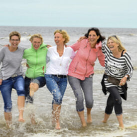 Freundinnen laufen gemeinsam am Strand von Norderney