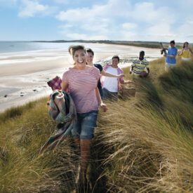 Gruppe auf einem Dünenweg am weiten Strand von Norderney