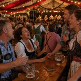 Freundesgruppe in Tracht feiert ausgelassen im Festzelt beim Oktoberfest Münster