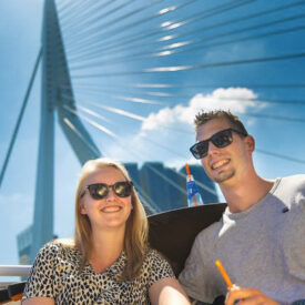 Zwei Reisende vor der Erasmusbrücke in Rotterdam