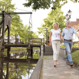 Paar bei einem Spaziergang an einer historischen Brücke in Papenburg