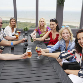 Gruppe beim Anstoßen auf der Terrasse des Strandhotels Het Hoge Duin