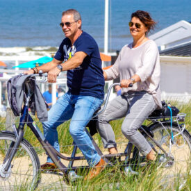 Paar fährt auf einem Tandem durch die Dünen von Egmond aan Zee