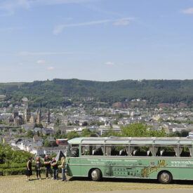 Oldtimerbus mit Gruppe in den Weinbergen über Trier