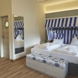 Zimmer im Wangerland Resort mit Doppelbett und maritimer Einrichtung