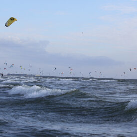 Wellen und Kitesurfer vor dem Strand von Wijk aan Zee