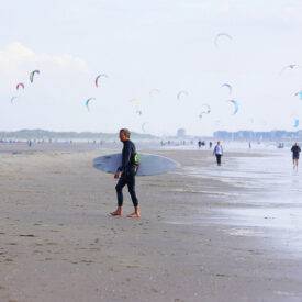 Breiter Strand von Wijk aan Zee mit Kitesurfern über dem Meer